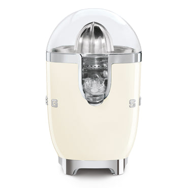 Exprimidor SMEG color crema, frontal, con diseño retro y tapa transparente
