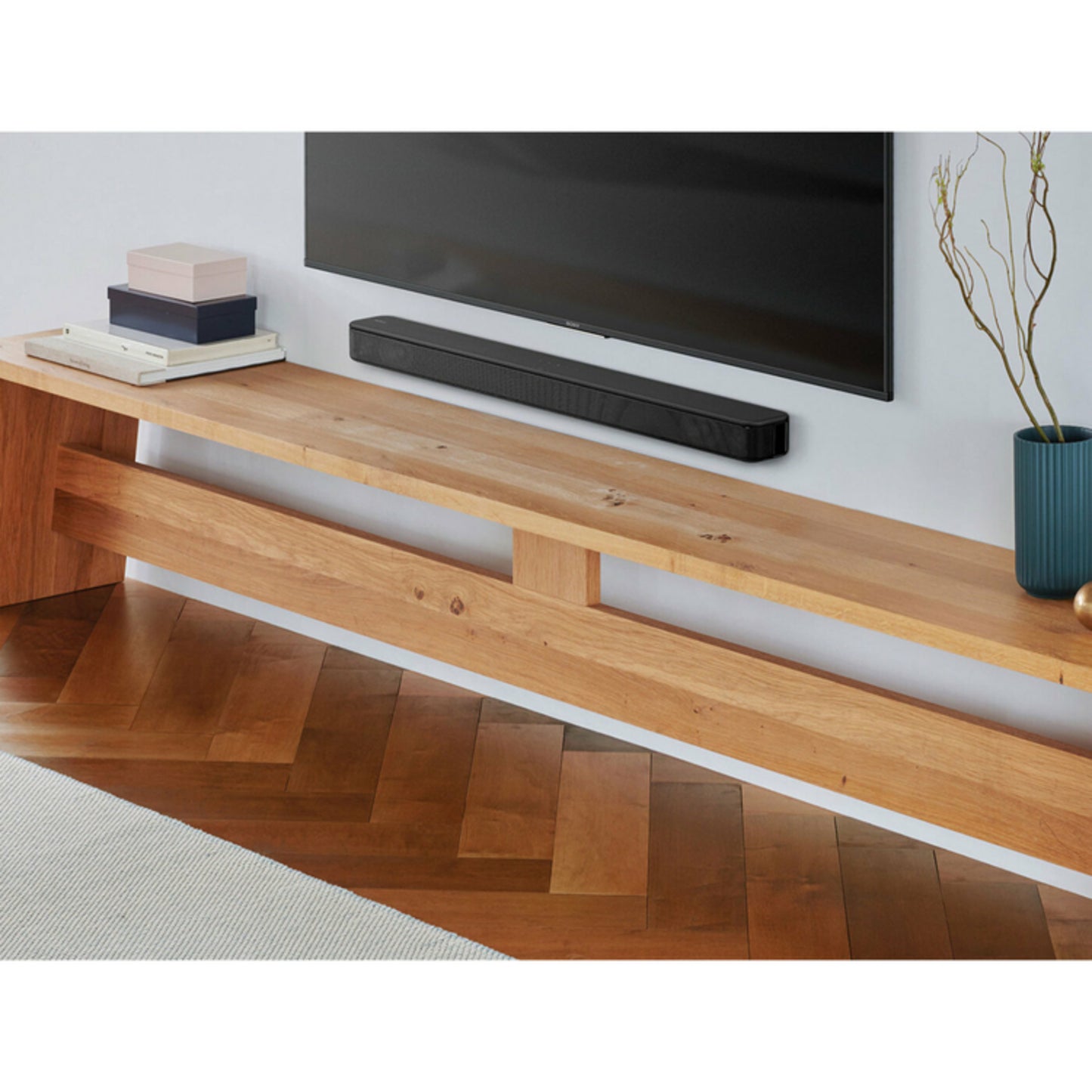 Barra de sonido Bluetooth Sony LL05 negra montada en pared debajo de televisor en sala moderna