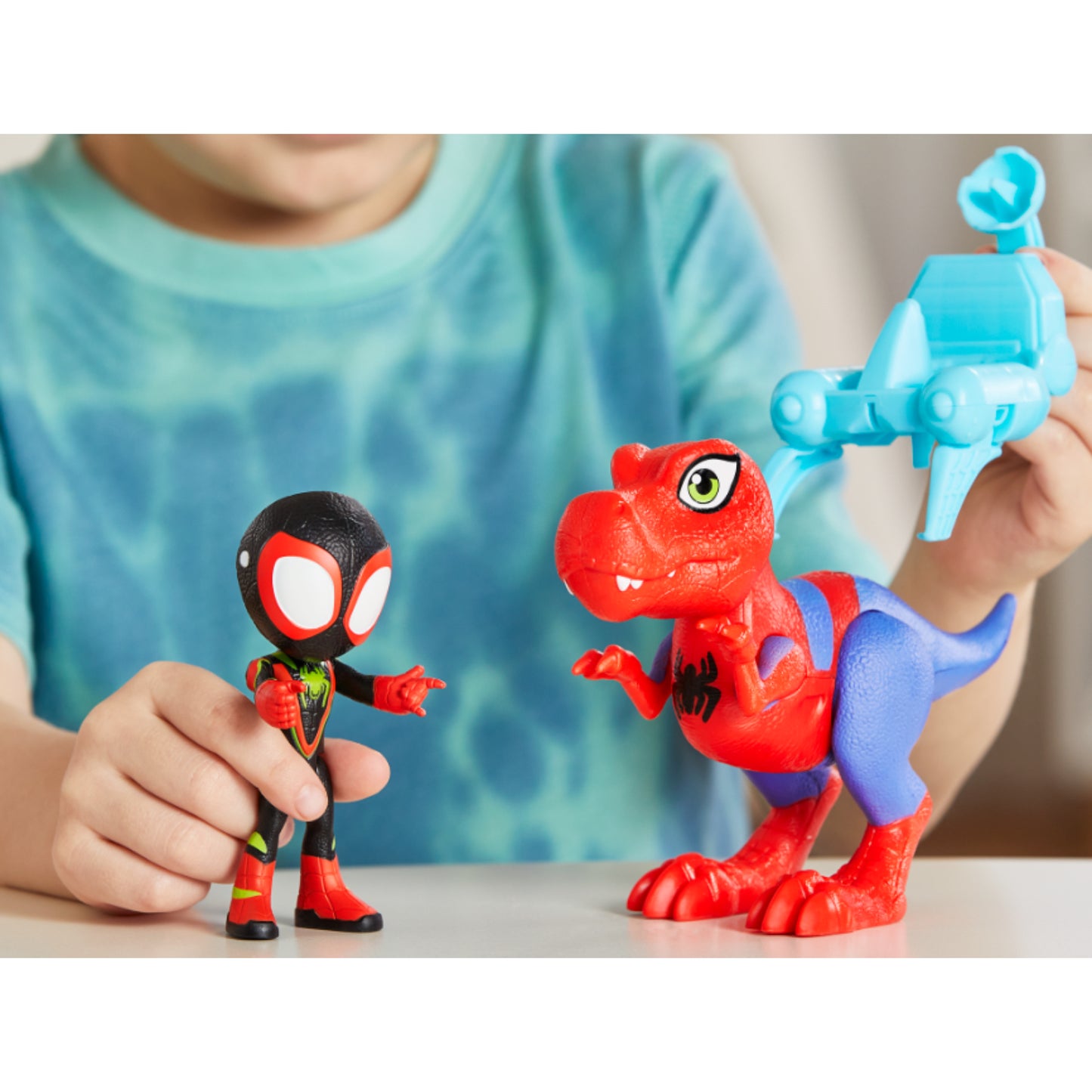 Figura de Spider-Man y dinosaurio rojo en manos de un niño, juego divertido