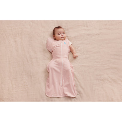 Swaddle rosa de LOVE TO DREAM, bebé acostado en una superficie suave