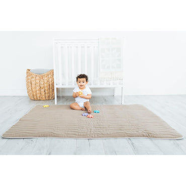 Alfombra de juego beige, niño sentado, habitación infantil