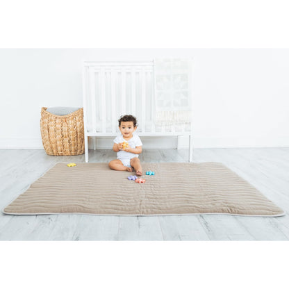 Alfombra de juego beige, niño sentado, habitación infantil
