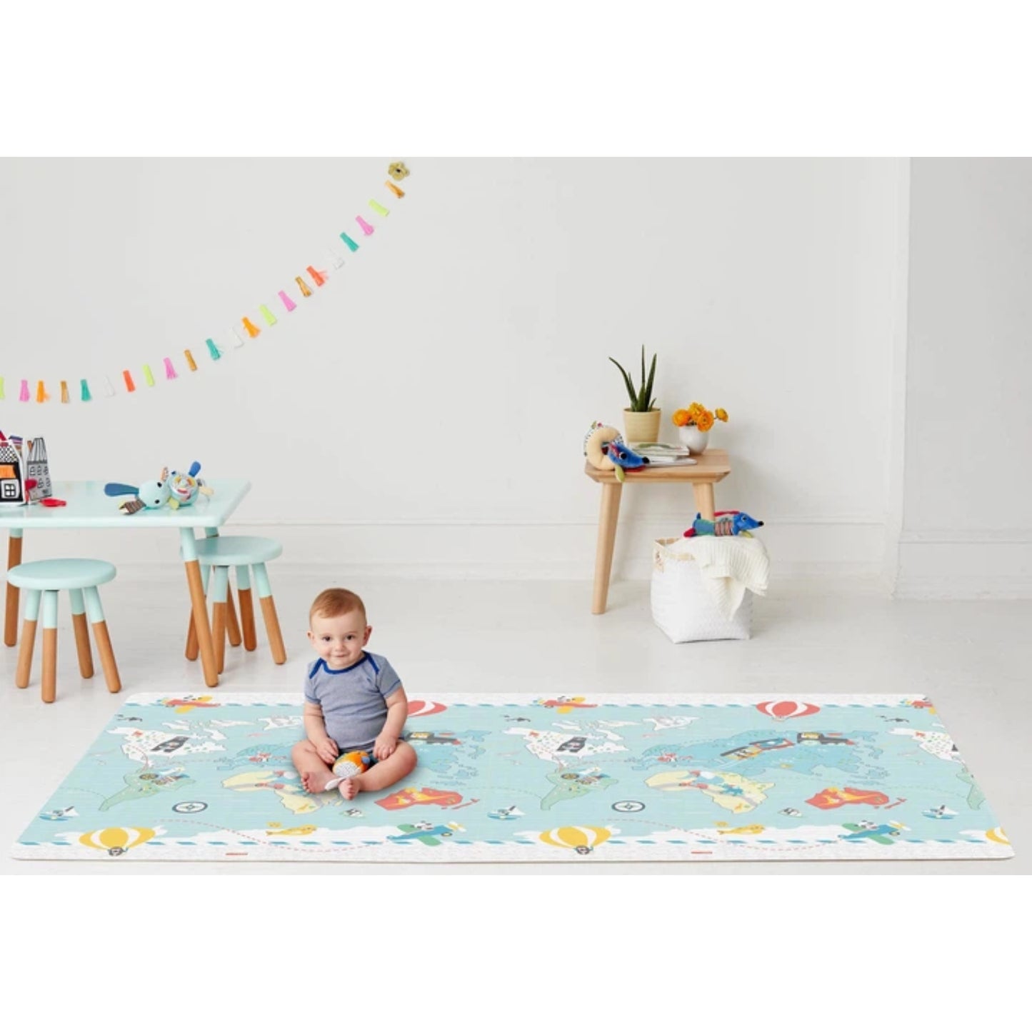 Alfombra para bebés SKIP*HOP azul con ilustraciones coloridas y vista amplia en sala de juegos