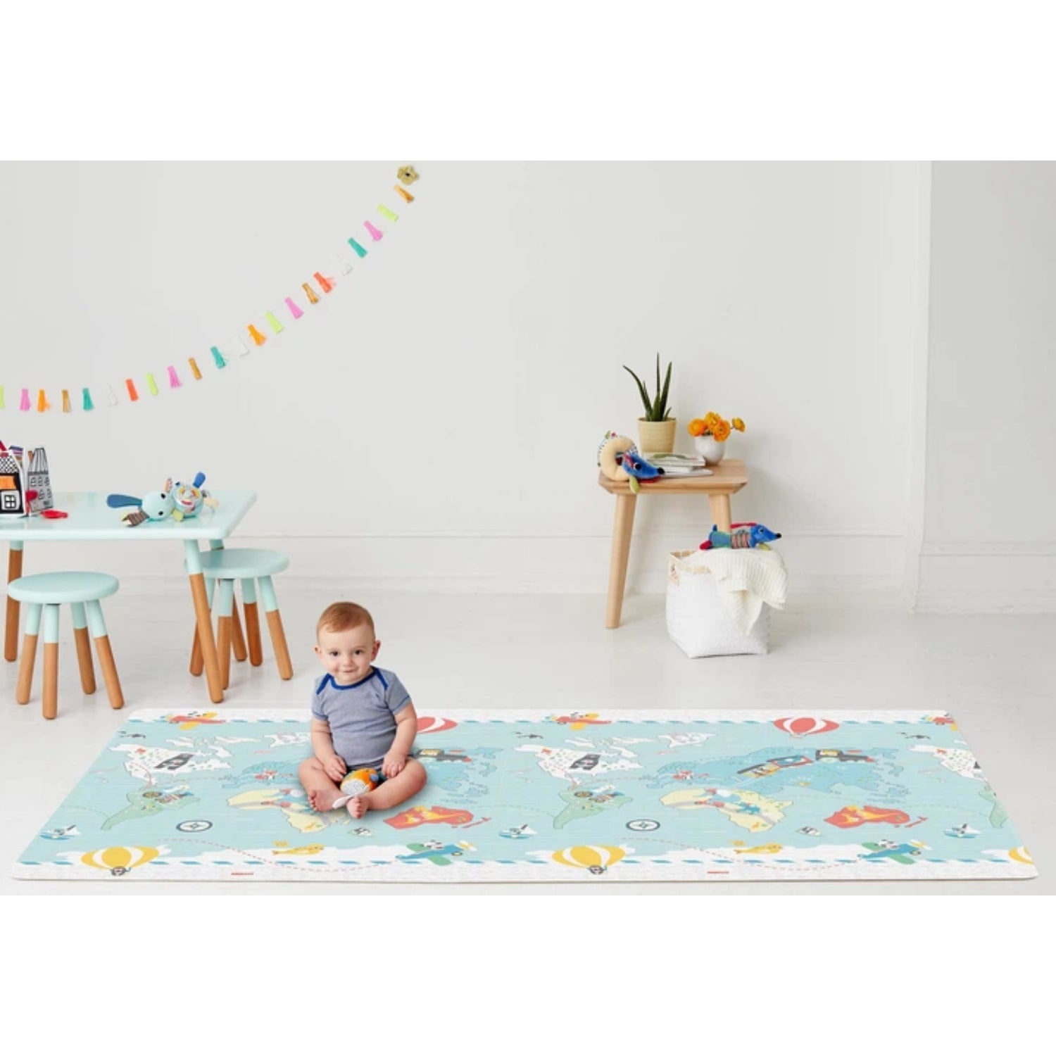 Alfombra para bebés SKIP*HOP azul con ilustraciones coloridas y vista amplia en sala de juegos