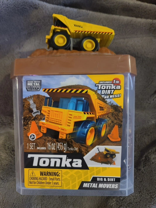 Juguete Tonka camión de metal amarillo, vista frontal en caja con tierra